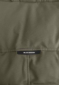 Olijfgroene stof met een gladde textuur heeft een horizontale pocket en een zwart merklabel met de tekst "BLCK BNNS."