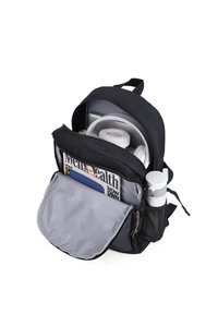 Zaino nero con interno grigio, scomparti con zip e oggetti visibili tra cui una rivista, auricolari e un portabottiglia.