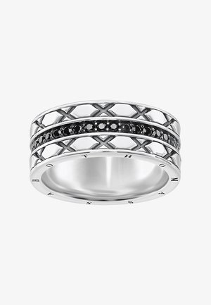 Bague en argent avec un design en treillis croisé et une rangée centrale de petites pierres rondes noires, gravée du nom de la marque sur le bord intérieur.