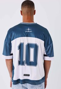 Uomo di spalle che indossa una maglia sportiva blu e bianca con il numero 10 e il logo "PXP" sulla schiena.