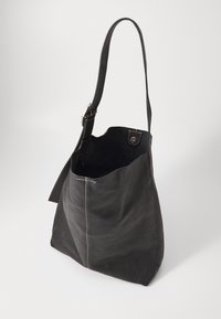 Bolsa tote de couro preto com uma textura suave, apresentando uma alça ajustável única e um detalhe de costura discreto. Design de topo aberto sem fecho.