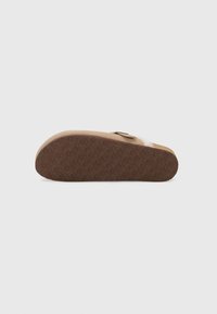 Brown slide sandal with a textured rubber sole, featuring a soft, fuzzy upper and a single adjustable strap for a secure fit.