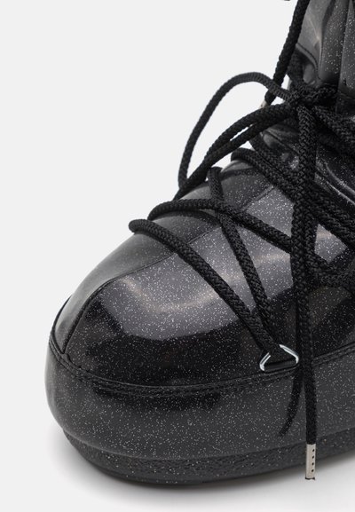 Black sparkling high-top shoe featuring a smooth, glossy texture, intricate black lacing, and a reinforced toe cap design.