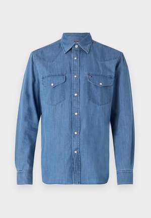 Lyseblå denimskjorte med lange ærmer, knaplukning fortil, spids krave, to brystlommer og sølvfarvede knapdetaljer.