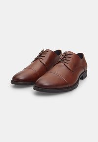 Scarpe eleganti in pelle marrone con punta rotonda, chiusura con lacci, cuciture decorative sul davanti e suola in gomma nera bassa.