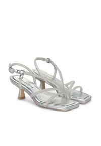 Zilveren sandalen met hakken, met een vierkante neus, slanke kruislingslopende bandjes en een gestructureerde afwerking. Lage blokhak.