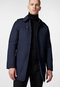Granatowy płaszcz o dopasowanym kroju, z zapięciem na guziki i usztywnionym kołnierzem. Charakteryzuje się gładką teksturą i bocznymi kieszeniami.