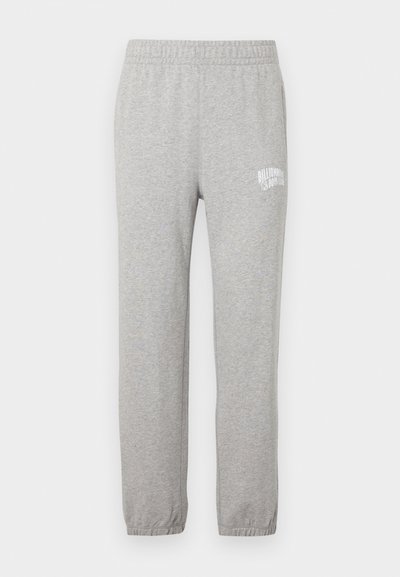 Hallid hallid puuvillased dressipüksid, millel on elastne vöökoht ja kitsenevad sääred. Vasakul reiel on valge logo. Sile tekstuur.