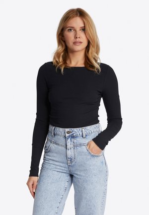 Black long-sleeve ribbed top paired with high-waisted light blue denim jeans, featuring front pockets and a button closure.