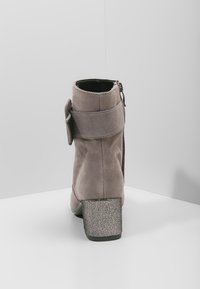 Botín gris de ante con cremallera lateral, correa ancha en el tobillo y tacón grueso plateado texturizado. Diseño sencillo con líneas limpias.