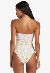 Maillot de bain une pièce multicolore à fleurs avec un design sans bretelles, texture côtelée, jambes hautes et teintes pastel de rose, bleu et vert.