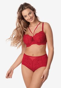 Czerwony koronkowy biustonosz z dodatkowymi paskami, ozdobiony teksturowanym kwiatowym wzorem. W zestawie z wysokim stanem, półprzezroczystymi czerwonymi majtkami.