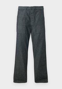 Pantalones de pierna ancha en gris oscuro con rayas verticales, grandes bolsillos frontales con parche, pasadores para cinturón y cremallera en la parte delantera.