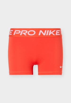 Φωτεινά πορτοκαλί συμπιεστικά σορτς Nike Pro με ευρύ ελαστικό στην μέση που έχει το κείμενο «NIKE PRO» και μικρό λευκό λογότυπο Nike στο αριστερό πόδι.