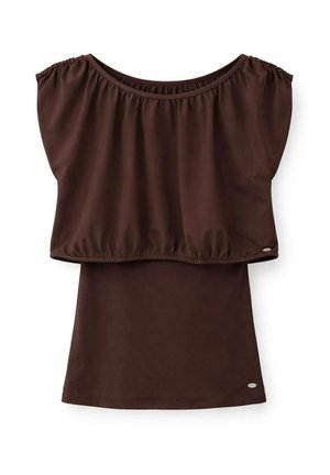 Bruine mouwloze top met brede geplooide volant-overlay en klein zilverkleurig merkembleem aan de zoom op witte achtergrond.