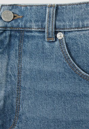 Denim spijkerbroek in een vervaagde blauwe kleur met contrasterende bruine stiksels, metalen knoopbevestiging en een klassieke vijf-pocketontwerp.