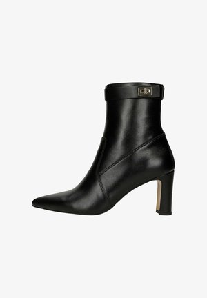 Stivaletto nero in pelle con punta affusolata, tacco a stiletto di media altezza e un elegante dettaglio con fibbia sulla cinghia della caviglia. Texture liscia.