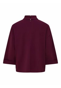 Blusa bordeaux con colletto alto, vestibilità comoda e maniche a 3/4. Presenta una corta cerniera sul retro e un tessuto liscio e strutturato.