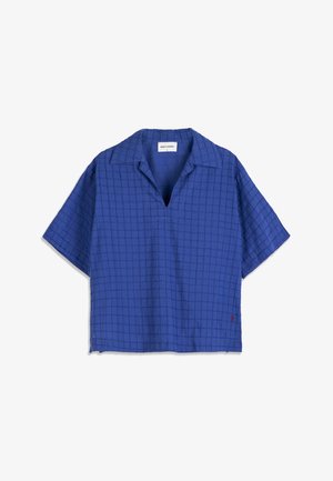 Chemise à manches courtes bleue avec un motif discret en quadrillage, col ouvert et un petit détail brodé rouge près de l'ourlet.
