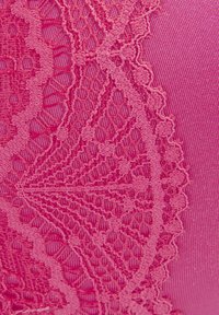 Roze stof met ingewikkelde kantdetails in een bloemenpatroon, met variërende texturen en een gladde onderliggende materie.