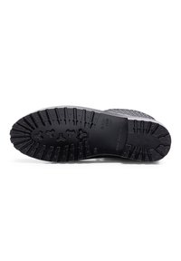 Semelle de chaussure noire avec des motifs de crampons profonds et rugueux conçus pour l’adhérence, indiquant "Made in Romania" et la taille 40.