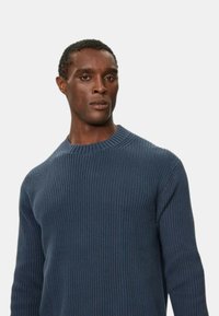 Maglione a coste blu navy con design a girocollo, maniche lunghe, tessuto testurizzato e silhouette aderente.