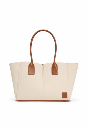 Sac fourre-tout en toile beige avec des accents en cuir marron, doté de deux poignées et d'une forme angulaire structurée. Surface texturée avec des lignes nettes.