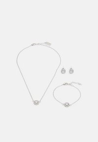 Drei-teiliges Schmuckset aus Silber; beinhaltet eine Halskette, ein Armband und Ohrringe. Jedes Stück hat ein kreisförmiges, funkeldes Stein-Mittelstück.