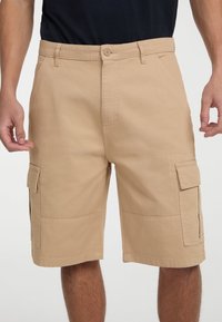 Khaki cargo šortky vyrobené z odolnej bavlny, s dvoma bočnými vreckami, dvoma prednými vreckami a zapínaním na gombík v páse.