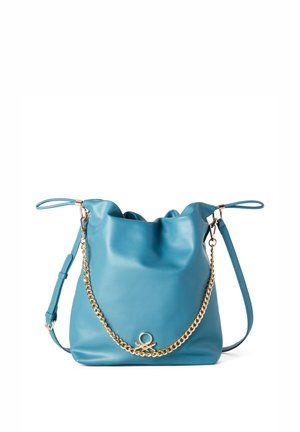 Sac seau en cuir bleu doux avec bandoulière ajustable et chaîne dorée décorative sur le devant, sur fond blanc.