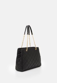 Svart quiltad läderhandväska med guldkedjeremmar, rektangulär form, slät yta och vevdetaljer på sidan.