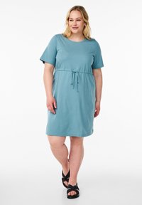 Une robe teal à manches courtes en tissu doux avec une taille à cordon de serrage et une coupe décontractée, comportant un col rond et une longueur au genou.