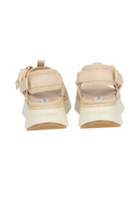 Beige Plattformsandalen mit geflochtenen Riemen, Gummisohle, verstellbarem Schnallenverschluss und strukturierten Akzenten. Die Markenkennzeichnung ist auf der Rückseite sichtbar.