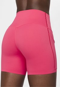 Bermudy sportowe w kolorze różowym, z wysokim stanem, wykonane z gładkiego, elastycznego materiału, z dopasowanym krojem i zdobieniem szwem z tyłu.