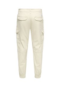 Pantalon cargo beige avec taille et poignets élastiques, doté de poches avant et arrière, texture lisse et coupe décontractée.