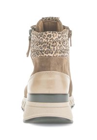 Beige en bruine enkelboot met een leren kraag met luipaardprint, zijknopen, suede en leren materialen, en een dikke rubberen zool, gezien van achter.