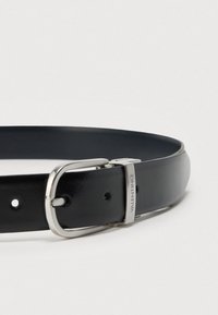 Černý kožený pásek se stříbrnou sponou a kovovou smyčkou s vyrytým slovem "VALENTINO" na bílém pozadí.