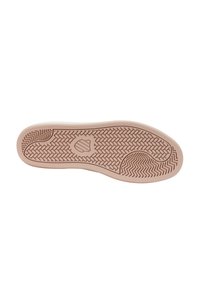 Suela de un zapato rosa claro con un diseño de suela que presenta texturas en zigzag y trenzado de cesta, y un emblema en forma de escudo en el centro.