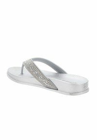 Des sandales en tongs argentées avec une semelle texturée, dotées d'une large bride métallique ornée de strass pour un détail supplémentaire.