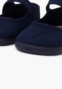 Marineblaue Leinenschlupfschuhe mit runder Zehenform, strukturierter Oberfläche und einem kleinen Ausschnitt im Obermaterial; Gummisohle für zusätzlichen Halt.