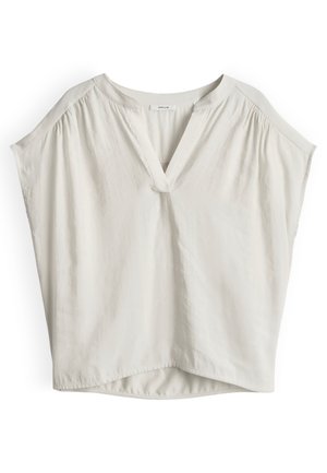 Blusa bianca larga a maniche corte con scollo a V e dettagli di tessuto arricciato sulle cuciture delle spalle.