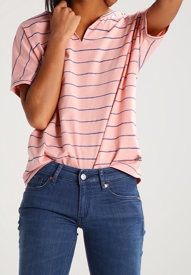 Růžové pruhované tričko s krátkým rukávem a výstřihem do V v kombinaci s tmavě modrými džíny. Měkká látka s uvolněným střihem a jemnými detaily u lemu.