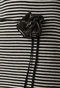 Μαύρος και άσπρος ριγωτός πλεκτός ύφασμα με υφή ρόζ λεπτομέρεια στο πλάι, διαθέτοντας απαλό φινίρισμα και αντίθετα άκρα.