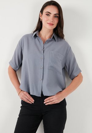 Gray short-sleeve button-up shirt with a collar, single chest pocket, and a relaxed fit. Fabric appears smooth and lightweight.