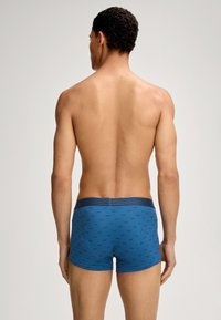 Siniset boxerit, joissa on kuvioitu design, vahvalla vyötärönauhan ja mukavan istuvuuden kanssa. Kangas on sileä.