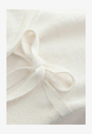 Un tissu tricoté blanc présente une texture douce avec un détail en nœud fait du même matériau, mettant en valeur un savoir-faire délicat et un design minimaliste.