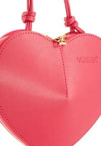 Herzförmige pinke Handtasche aus strukturiertem synthetischen Material. Verfügt über einen goldenen Reißverschluss und das eingravierte Logo 'VENEZIA' auf der Oberfläche.