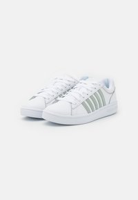 Sneaker bianche con strisce verdi, tomaia in pelle testurizzata, lacci piatti e suola in gomma, con dettagli del logo sul lato.