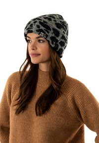 Gorro de punto en gris con un patrón de estampado de leopardo negro. Textura suave con un dobladillo enrollado y una etiqueta que dice "Sé salvaje".