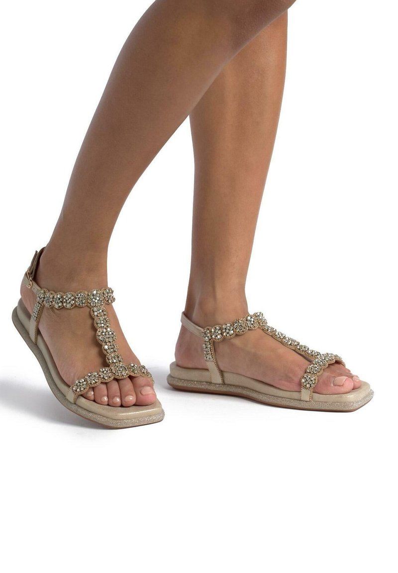Beige sandalen met een T-band ontwerp, voorzien van versieringen van rhinestones en een gestructureerde zool, geschikt voor casual draagstijl.